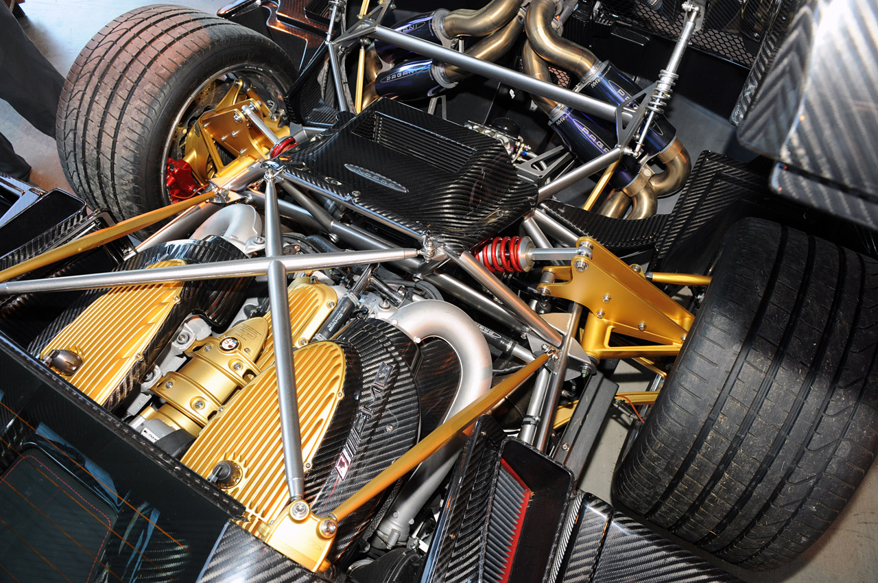 The engine bay of a Pagani Huayra showing the twin turbo V12 as well as fancy bespoke suspension bits.