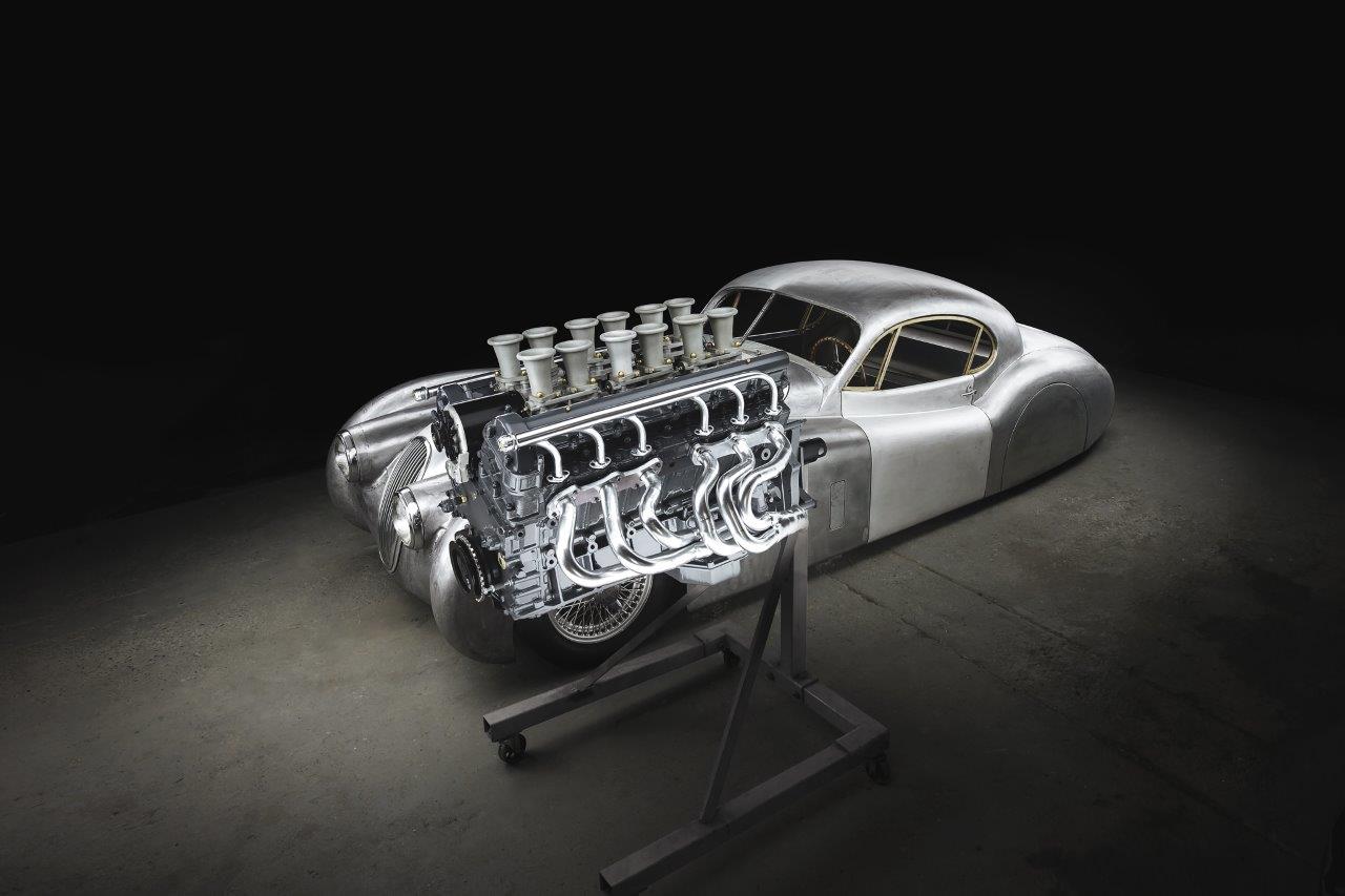 The XK120 LM is pictured during the metalwork stage of its construction, unpainted and with its new V12 engine in the foreground.