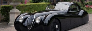 The Jaguar XK120 LM sits outside Sir William Lyons' country house.|Side view of the black-on-black XK120 LM showing off its sleek